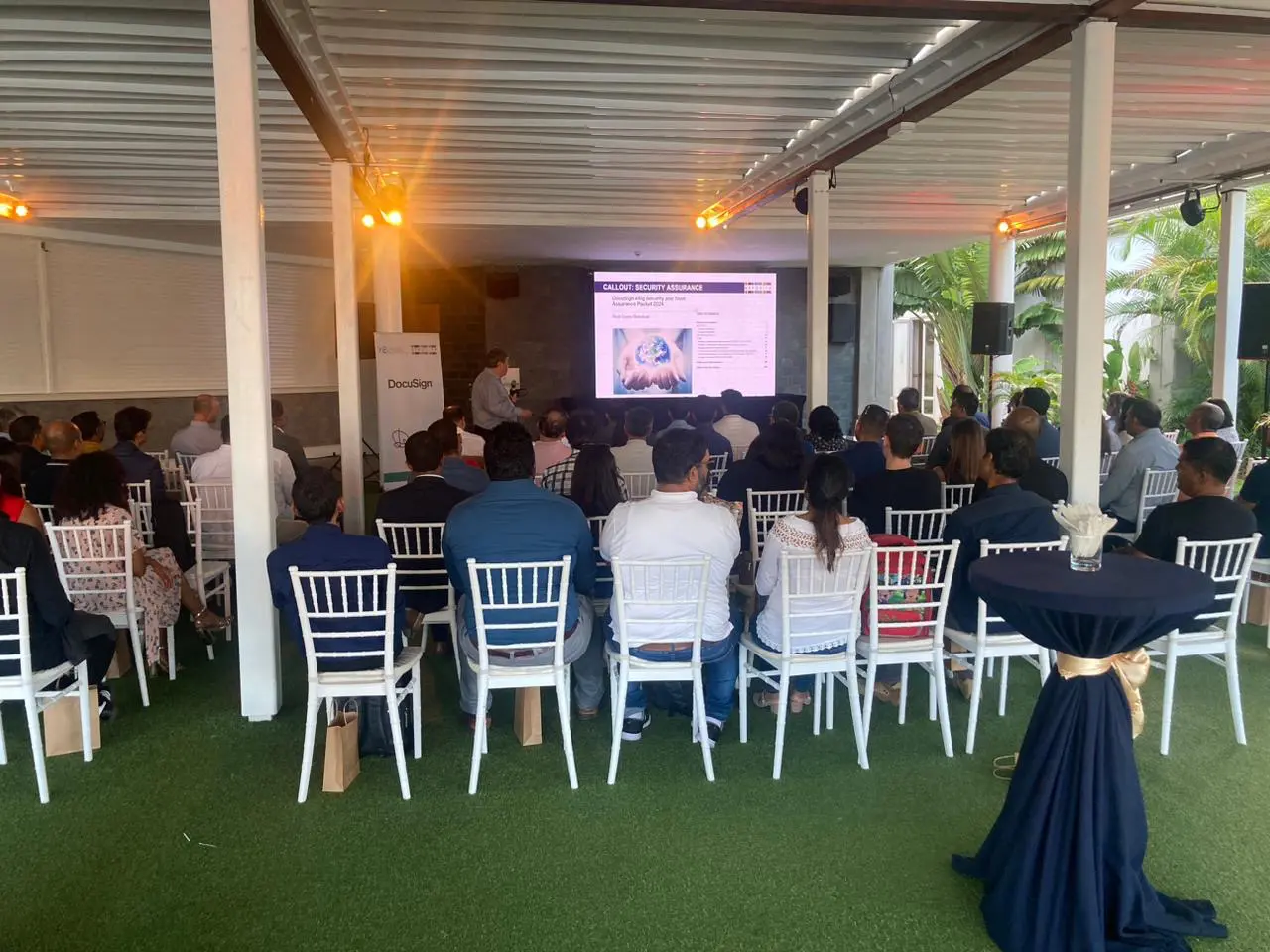Audience attending a presentation in covered venue.