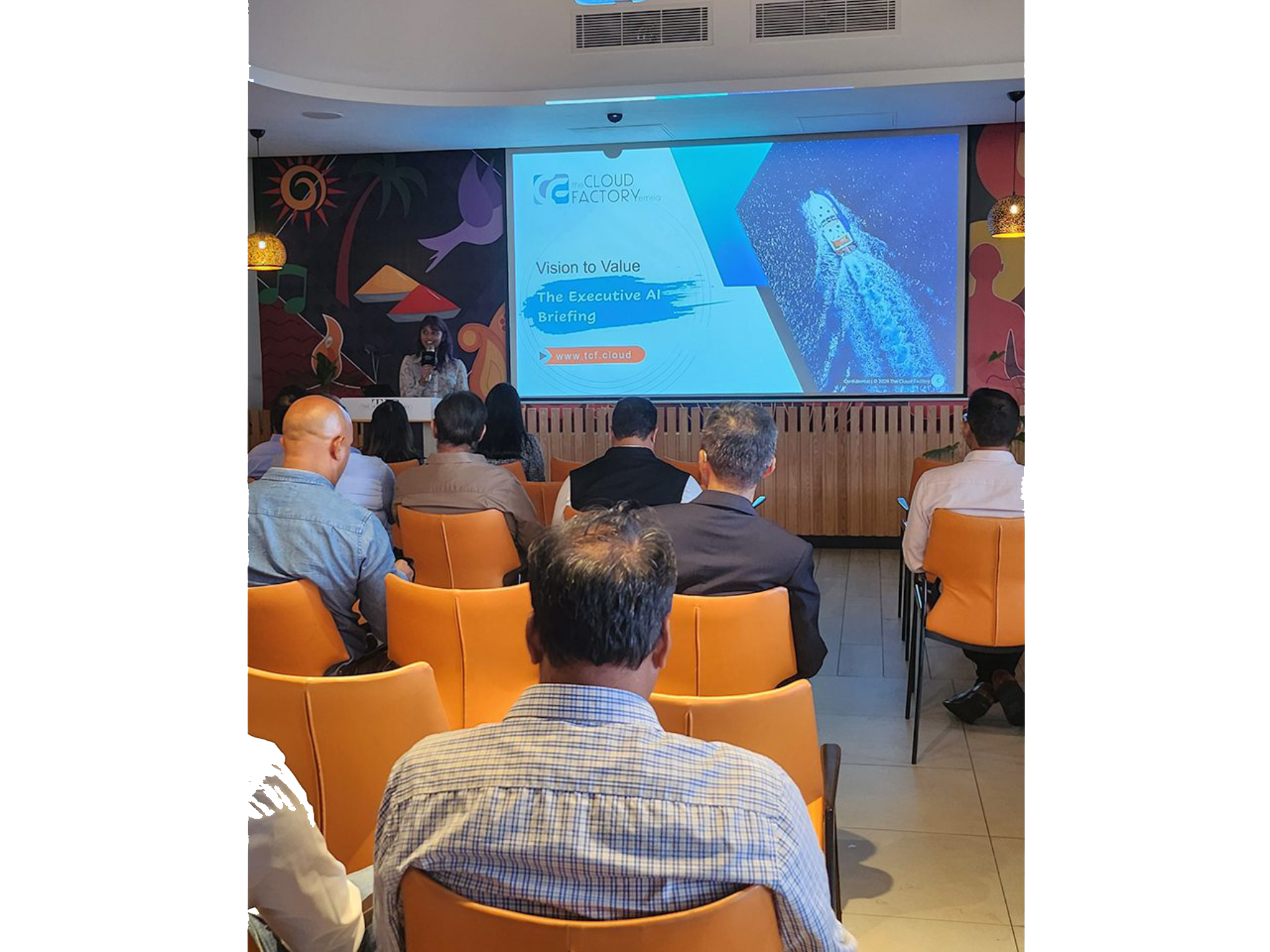 Audience attending a presentation in conference room.