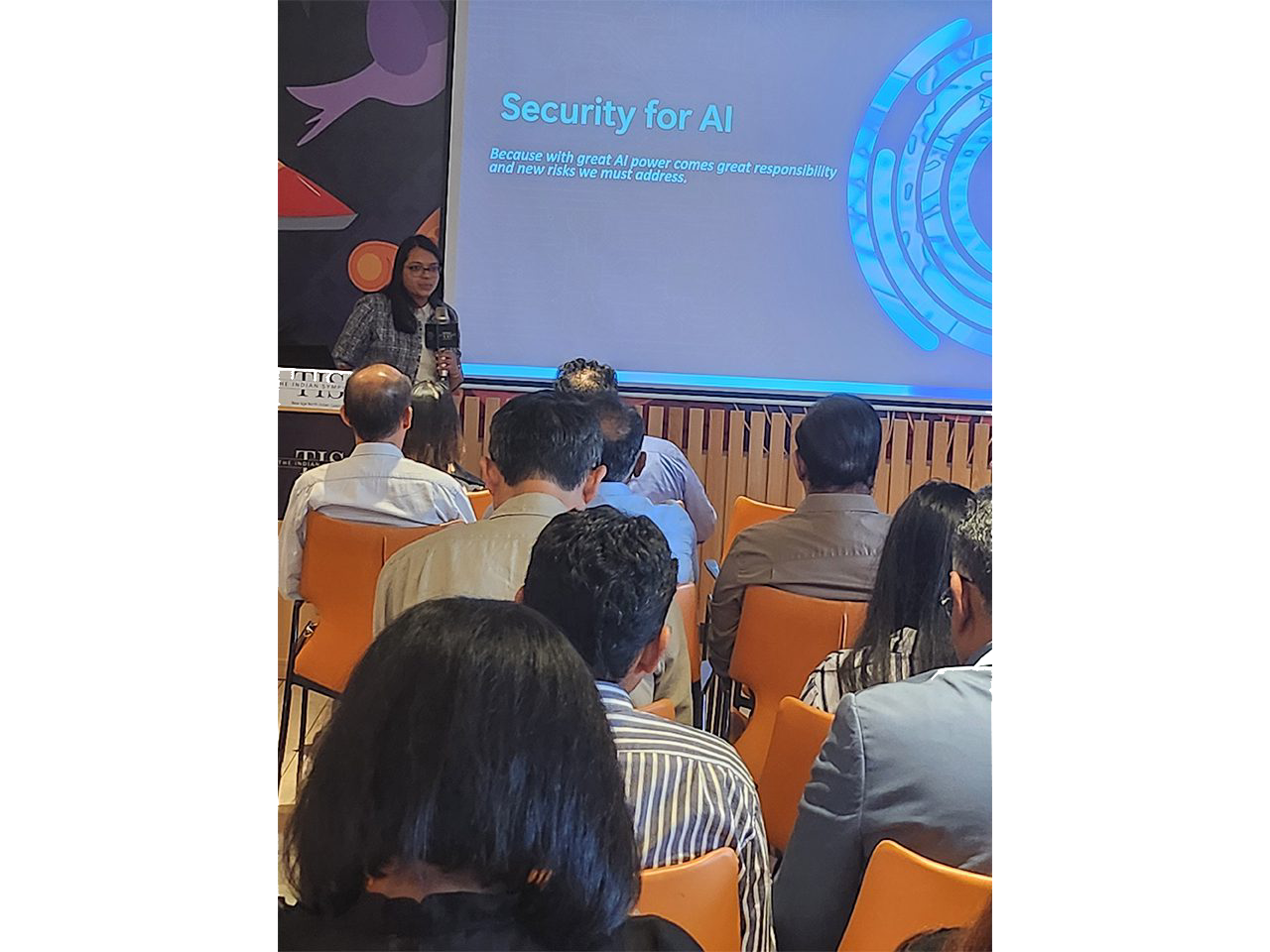 Audience attending AI security presentation in conference.