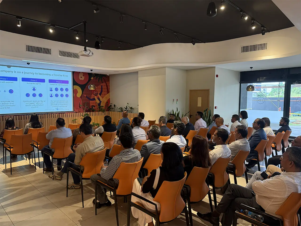 Presentation on company growth stages with attendees in a modern conference room